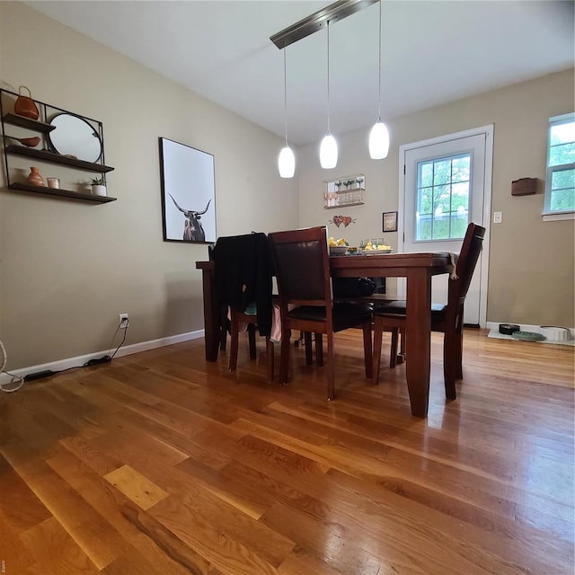 dining space featuring baseboards and light wood-style flooring