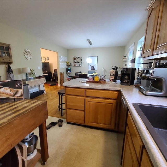 kitchen featuring brown cabinets, light countertops, black electric cooktop, a peninsula, and open floor plan