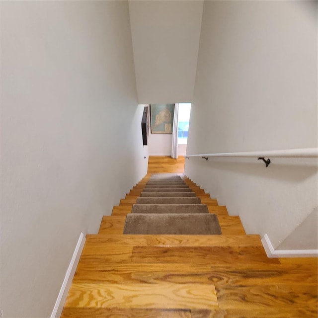 stairway featuring baseboards and wood finished floors