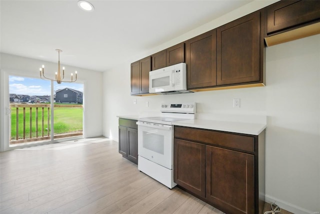 kitchen with light wood-style floors, dark brown cabinetry, light countertops, an inviting chandelier, and white appliances