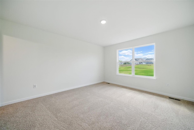unfurnished room with baseboards, visible vents, and carpet