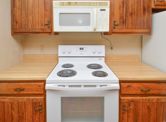 kitchen with white appliances, brown cabinets, and light countertops