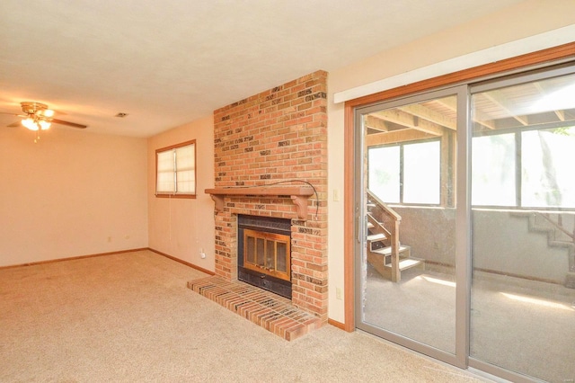 unfurnished living room featuring baseboards, ceiling fan, carpet flooring, and a brick fireplace