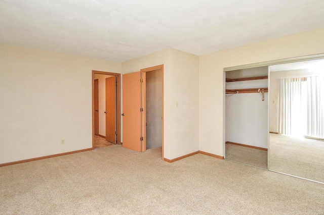 unfurnished bedroom featuring baseboards, carpet, and a closet