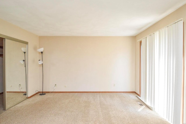 empty room with light colored carpet and baseboards