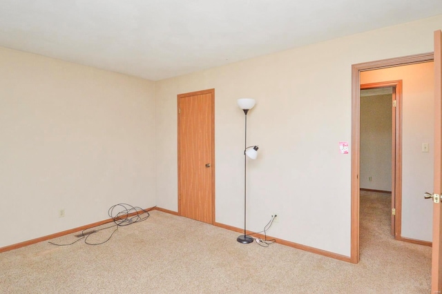 carpeted empty room featuring baseboards