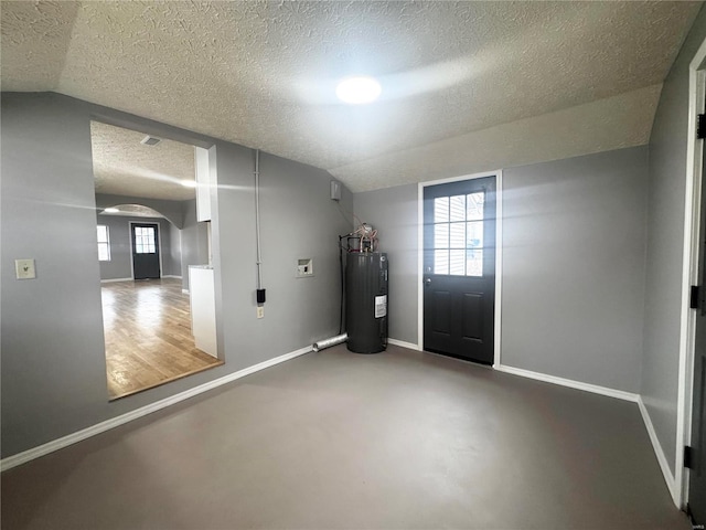 entryway with a textured ceiling, finished concrete flooring, arched walkways, baseboards, and electric water heater