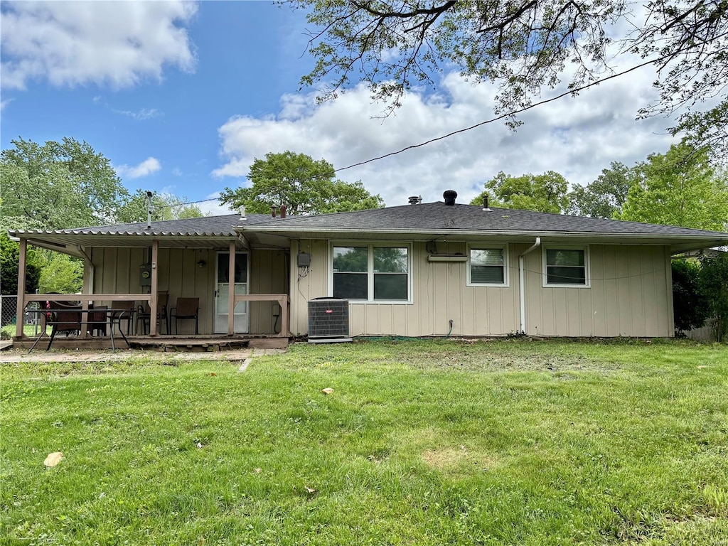 back of property with a yard, a deck, and central air condition unit