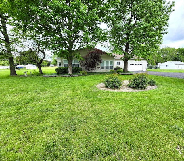 view of yard with a garage and driveway