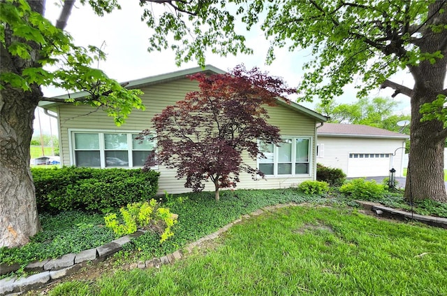 view of property exterior with an attached garage and a lawn