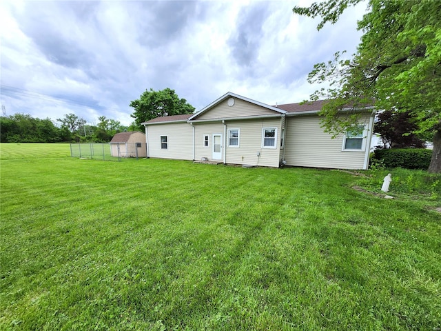back of property with fence and a yard
