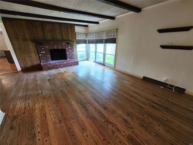 unfurnished living room featuring a fireplace, baseboards, wood-type flooring, and beam ceiling