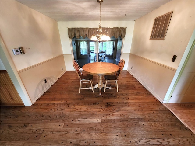 dining area featuring a notable chandelier, visible vents, and dark wood finished floors
