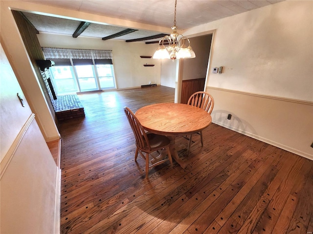 dining space featuring beamed ceiling, an inviting chandelier, baseboards, and hardwood / wood-style floors