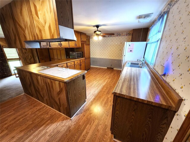 kitchen with light wood-style flooring, a healthy amount of sunlight, white appliances, and wallpapered walls