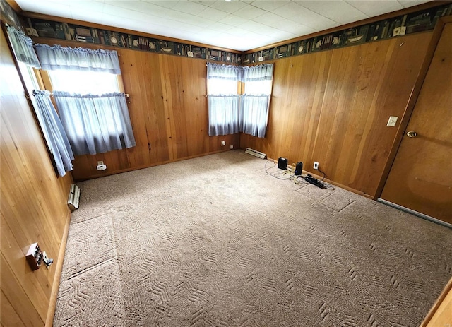 unfurnished room featuring carpet flooring, wooden walls, and baseboard heating