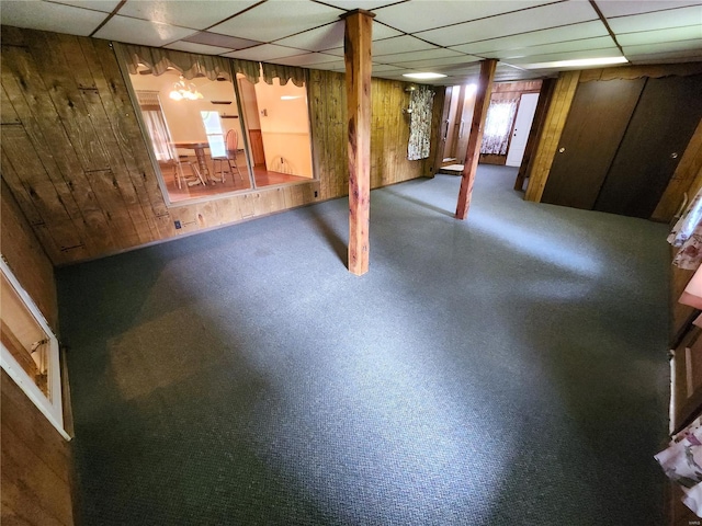 below grade area featuring wood walls and a paneled ceiling