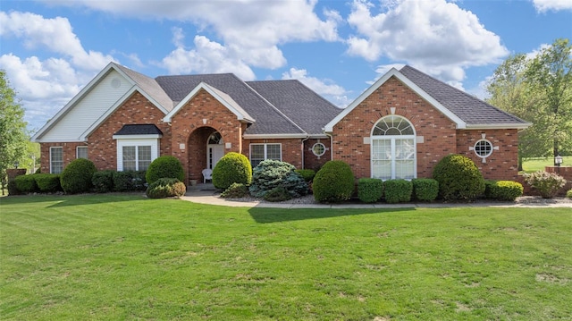 view of front facade featuring a front yard and brick siding