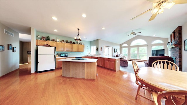 kitchen featuring light wood finished floors, light countertops, a center island, freestanding refrigerator, and visible vents