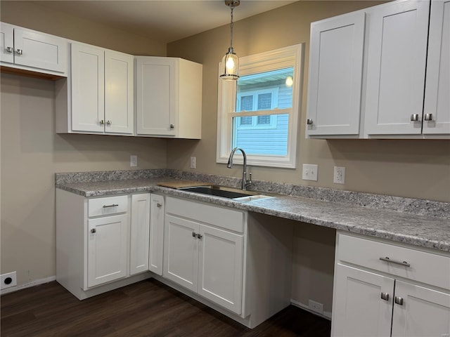 kitchen with a sink, dark wood-style flooring, and white cabinets
