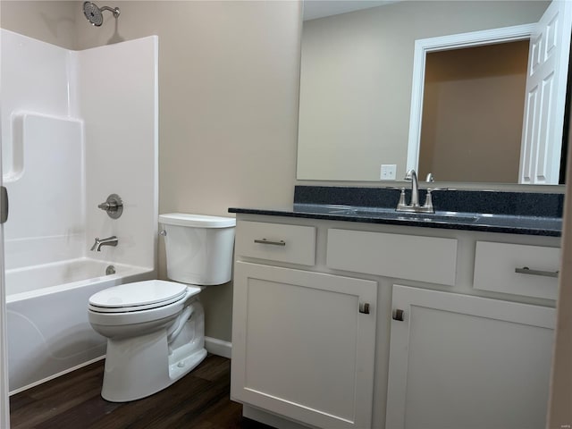 full bath featuring bathtub / shower combination, wood finished floors, vanity, baseboards, and toilet