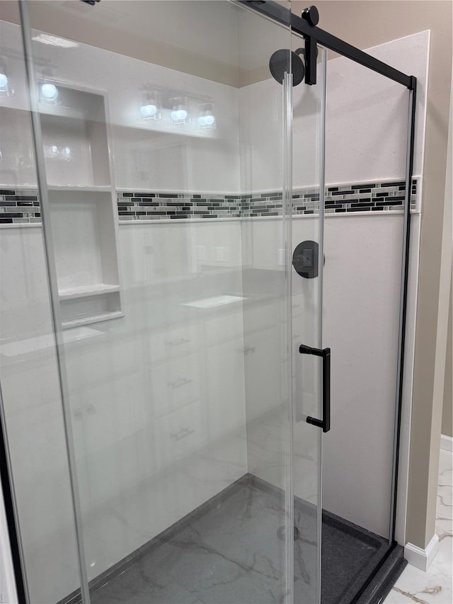 full bath featuring marble finish floor and a stall shower