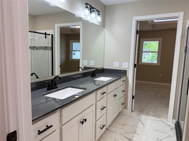 bathroom with baseboards, a sink, marble finish floor, and a stall shower