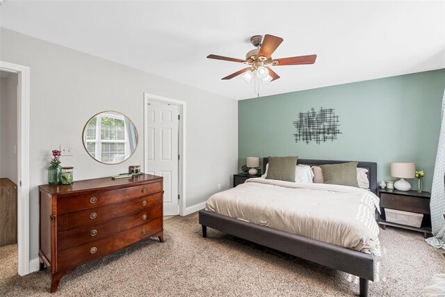carpeted bedroom featuring baseboards and ceiling fan