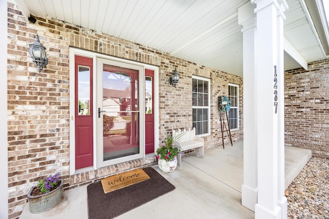 entrance to property with brick siding and covered porch