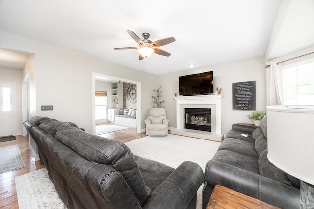living room featuring ceiling fan, a healthy amount of sunlight, and wood finished floors