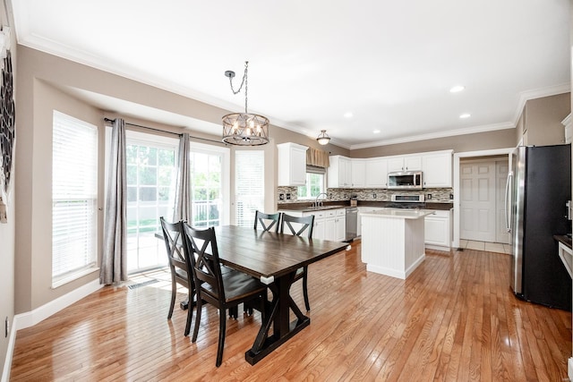 dining space featuring recessed lighting, an inviting chandelier, ornamental molding, and light wood-style floors