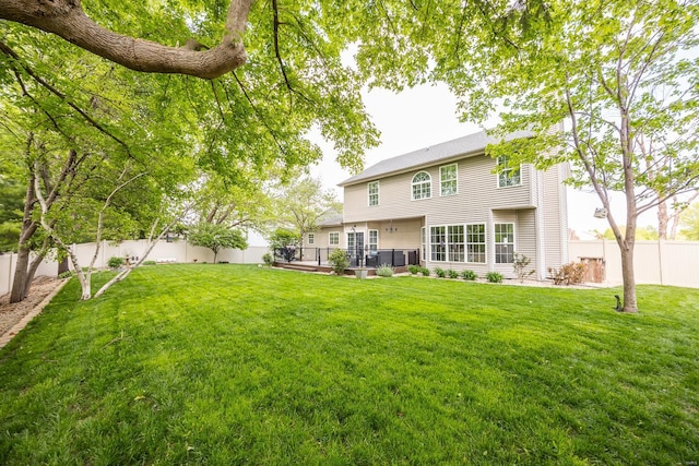 rear view of house featuring a patio, a fenced backyard, and a yard