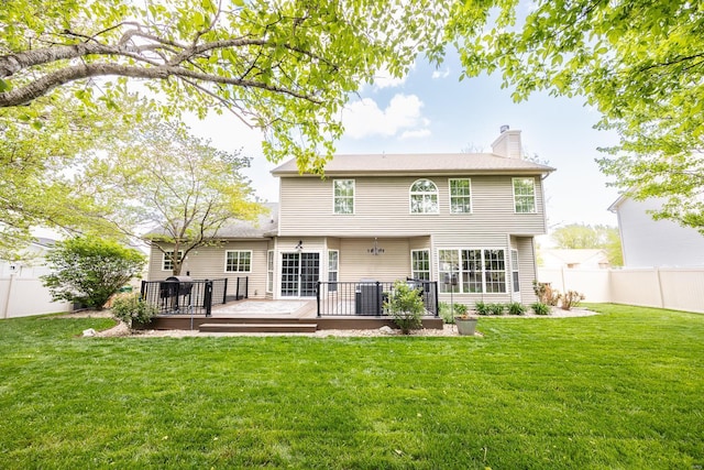 rear view of house with a lawn, a fenced backyard, and a chimney