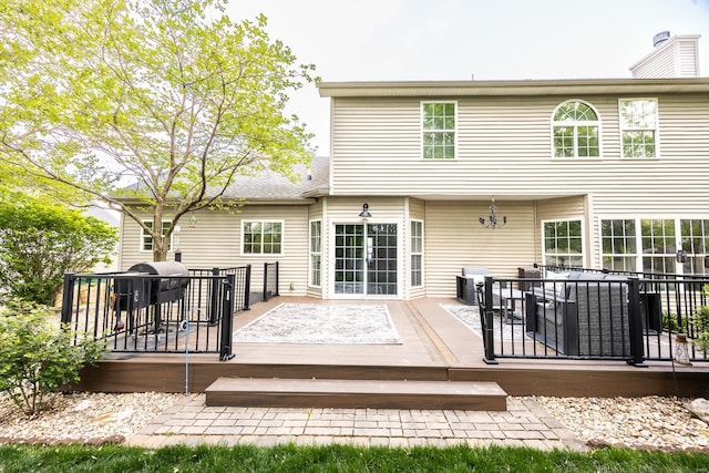 back of house featuring a wooden deck and a chimney