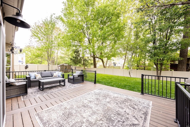 wooden terrace featuring a fenced backyard, a lawn, and an outdoor living space