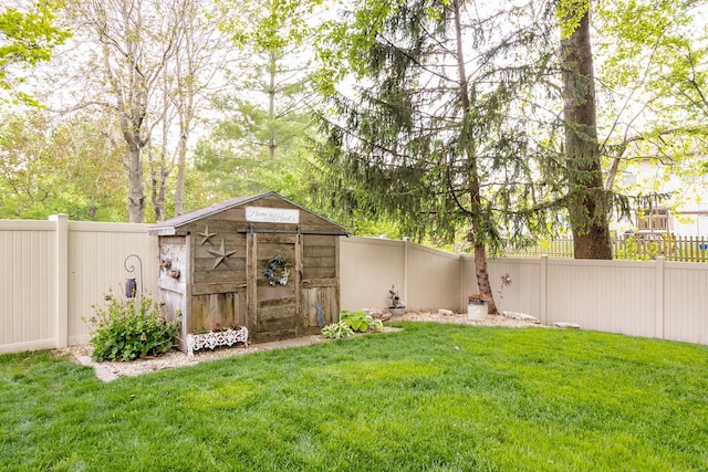 view of yard featuring a fenced backyard, an outbuilding, and a shed