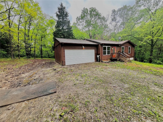 view of front of home featuring dirt driveway and a garage