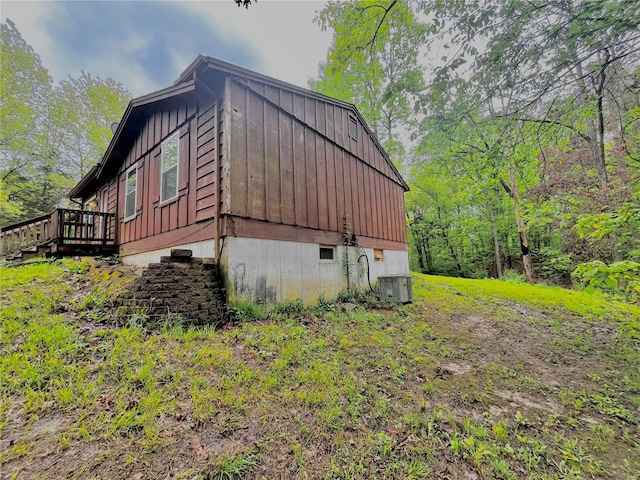 view of home's exterior with board and batten siding, central air condition unit, and a deck