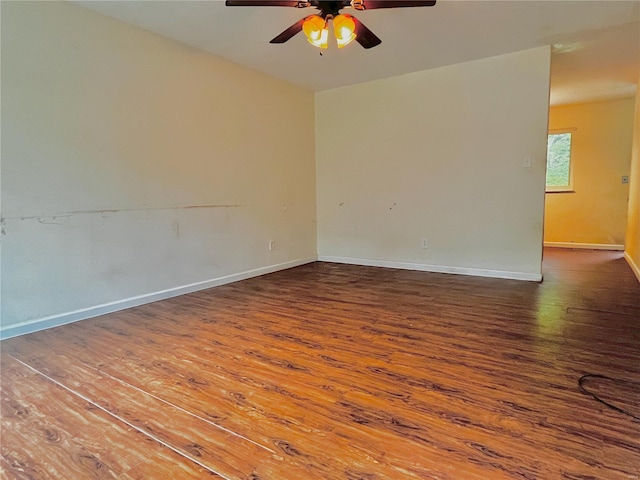 empty room with a ceiling fan, baseboards, and wood finished floors