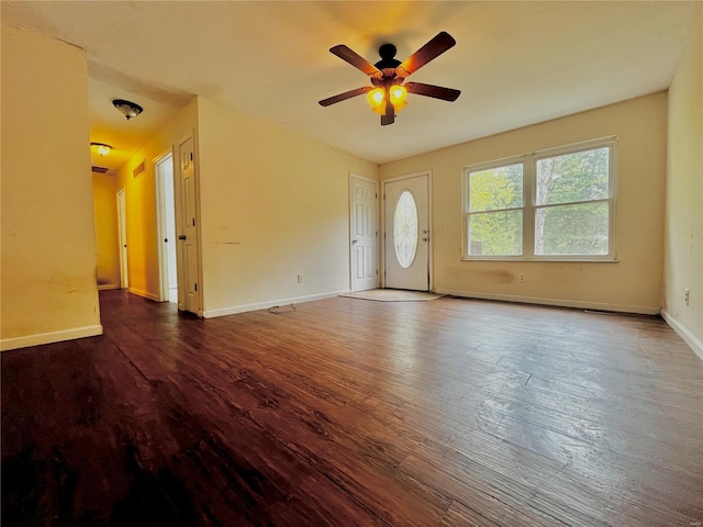 interior space featuring baseboards, a ceiling fan, and wood finished floors