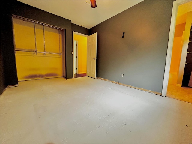 unfurnished bedroom featuring unfinished concrete floors, a ceiling fan, and a closet