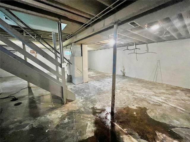 unfinished below grade area with visible vents, heating unit, and stairs