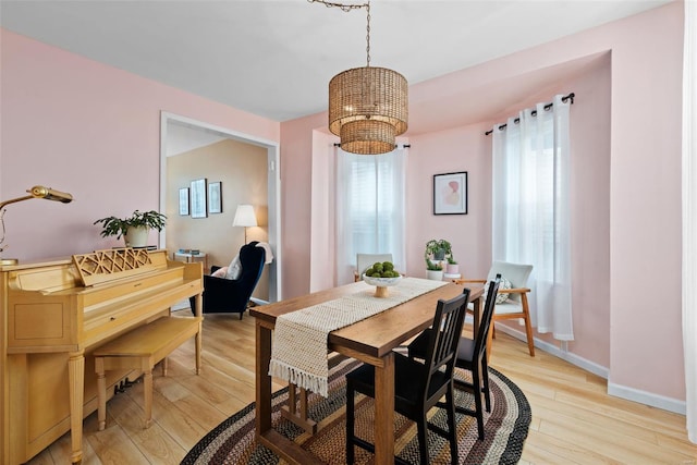 dining room featuring plenty of natural light, light wood-style floors, and a chandelier
