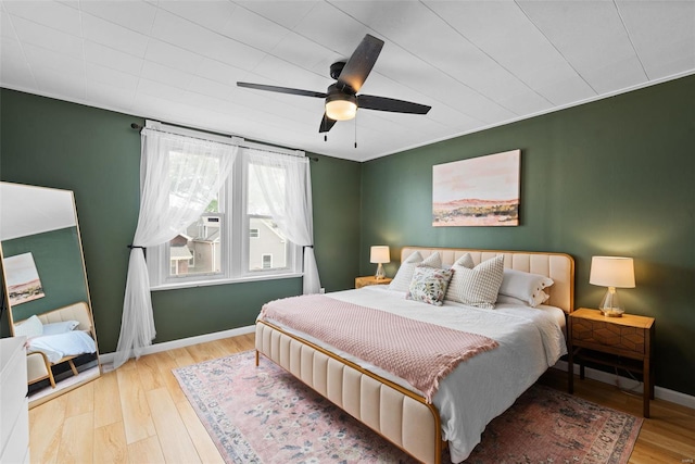 bedroom featuring baseboards, ceiling fan, and wood finished floors