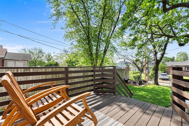 wooden terrace featuring a lawn and fence