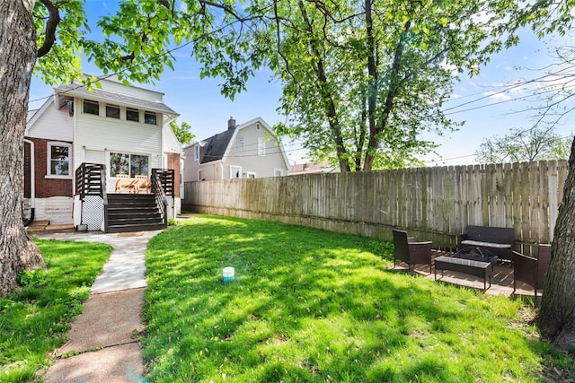 view of yard featuring a wooden deck, a fenced backyard, and stairs
