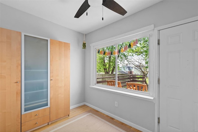 unfurnished room with baseboards, a ceiling fan, and wood finished floors
