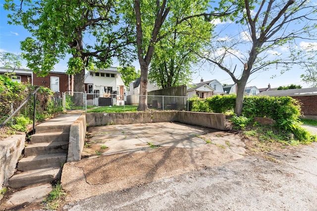 view of yard featuring a gate, fence, and a residential view