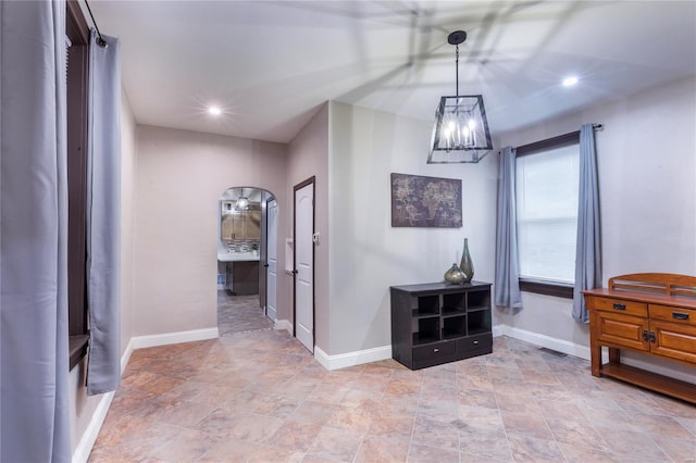 hallway with baseboards, stone finish floor, and recessed lighting