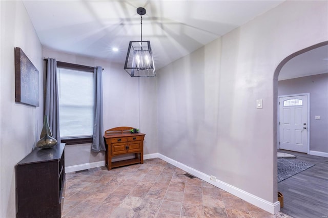 dining room with baseboards, arched walkways, visible vents, and an inviting chandelier